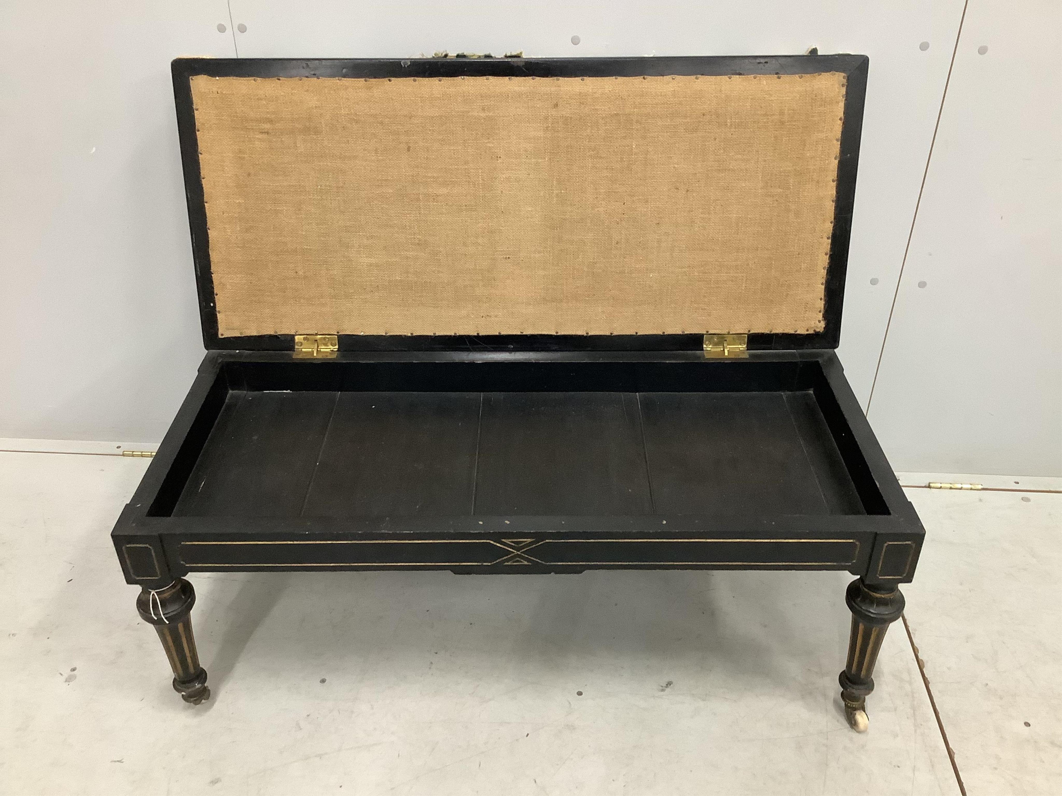 A late Victorian ebonised stool with hinged box seat, width 113cm, depth 49cm, height 50cm. Condition - fair, upholstery poor